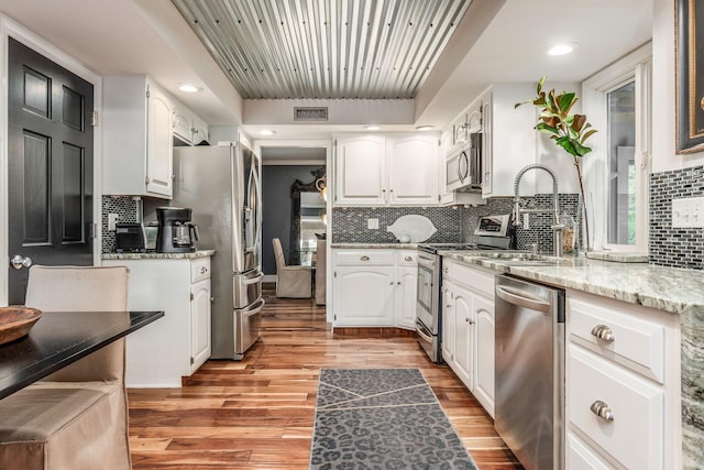 8547 Pitlochry Ct, Dublin, OH 43017 - kitchen with stainless steel appliances, white cabinets, tasteful backsplash, and recessed lighting