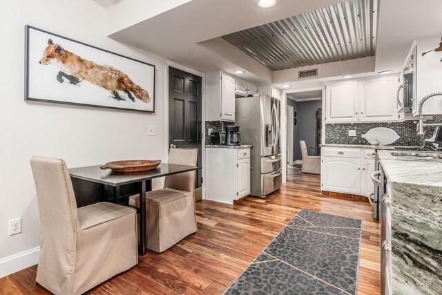8547 Pitlochry Ct, Dublin, OH 43017 - kitchen with appliances with stainless steel finishes, white cabinetry, light wood-style floors, and recessed lighting