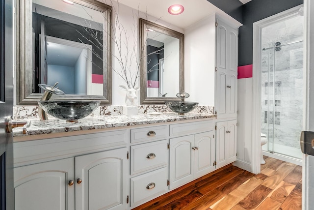 8547 Pitlochry Ct, Dublin, OH 43017 - full bathroom with a stall shower, toilet, double vanity, and wood finished floors