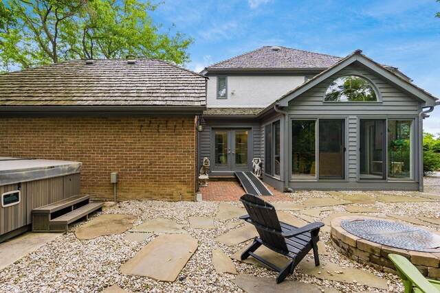 8547 Pitlochry Ct, Dublin, OH 43017 - back of house featuring french doors, an outdoor fire pit, a hot tub, a patio area, and brick siding