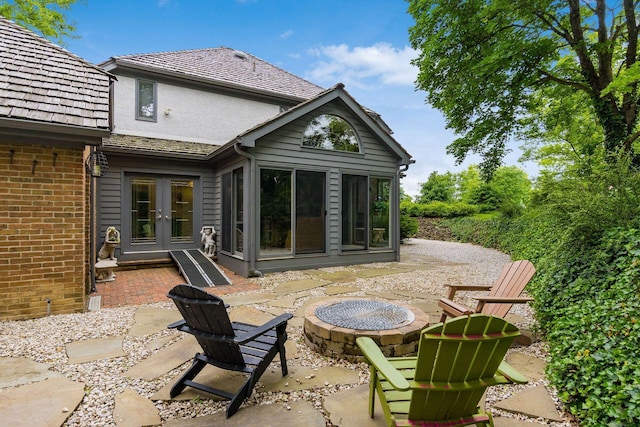 8547 Pitlochry Ct, Dublin, OH 43017 - back of property with french doors, a fire pit, a patio area, brick siding, and a sunroom
