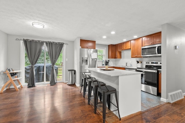 4373 Valley Quail Blvd S, Westerville, OH 43081 - kitchen featuring stainless steel appliances, baseboards, a breakfast bar area, a kitchen island, and a sink