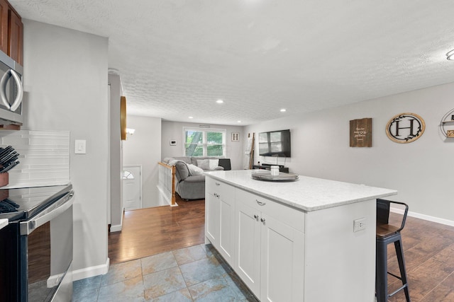 4373 Valley Quail Blvd S, Westerville, OH 43081 - kitchen featuring appliances with stainless steel finishes, a kitchen breakfast bar, a kitchen island, recessed lighting, and open floor plan
