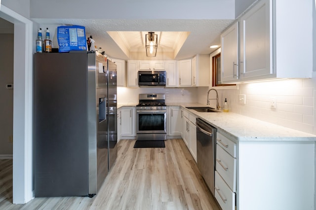3243 Brookview Way Unit 68, Columbus, OH 43221 - kitchen featuring appliances with stainless steel finishes, a raised ceiling, a sink, light wood-type flooring, and tasteful backsplash