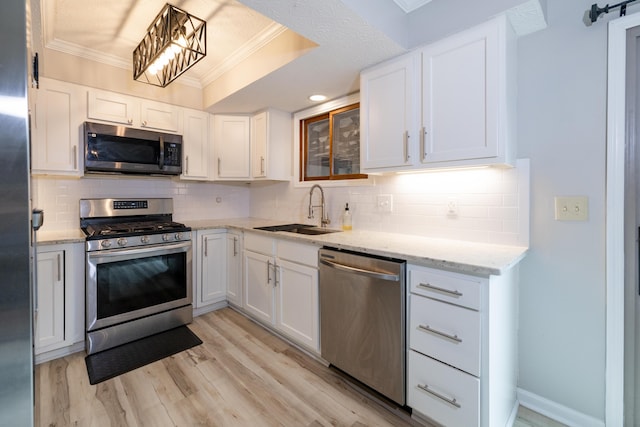 3243 Brookview Way Unit 68, Columbus, OH 43221 - kitchen with stainless steel appliances, a sink, ornamental molding, white cabinetry, and light wood finished floors