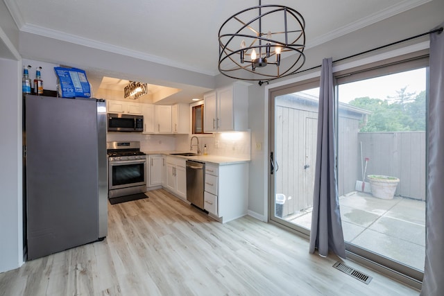 3243 Brookview Way Unit 68, Columbus, OH 43221 - kitchen with appliances with stainless steel finishes, a chandelier, crown molding, a sink, and light wood finished floors