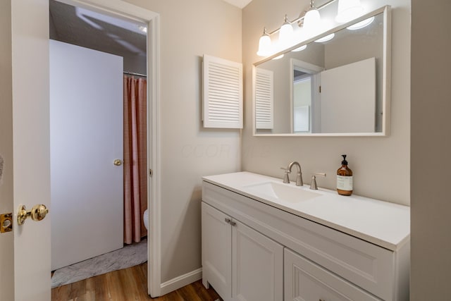 3243 Brookview Way Unit 68, Columbus, OH 43221 - bathroom with wood finished floors, toilet, vanity, baseboards, and a shower with shower curtain