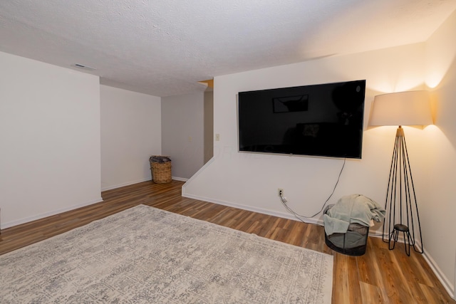 3243 Brookview Way Unit 68, Columbus, OH 43221 - unfurnished living room featuring wood finished floors, baseboards, and a textured ceiling