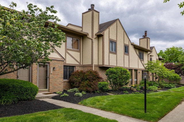 3243 Brookview Way Unit 68, Columbus, OH 43221 - view of front of home featuring stucco siding, a chimney, brick siding, and a front yard