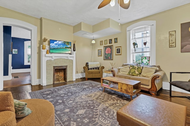 1904 Cedar Hill Rd, Lancaster, OH 43130 - living room featuring a ceiling fan, wood finished floors, a fireplace, baseboards, and a textured ceiling