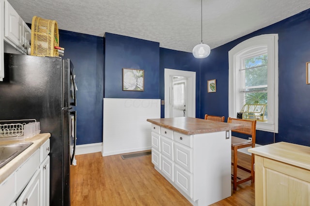 1904 Cedar Hill Rd, Lancaster, OH 43130 - kitchen with freestanding refrigerator, a textured ceiling, light wood-style floors, white cabinetry, and baseboards