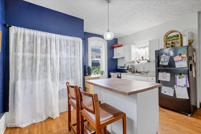1904 Cedar Hill Rd, Lancaster, OH 43130 - kitchen with freestanding refrigerator, stainless steel range with electric stovetop, white cabinets, light wood-type flooring, and a textured ceiling