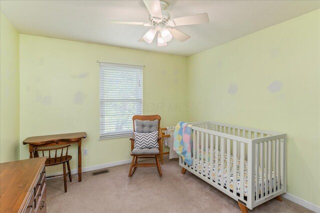 4560 Greyson Dr, Powell, OH 43065 - carpeted bedroom with baseboards, ceiling fan, and a crib