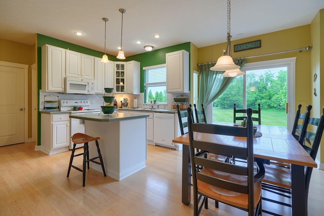 6612 Archie Ct, Canal Winchester, OH 43110 - kitchen with white appliances, decorative backsplash, light wood-style flooring, a kitchen island, and white cabinetry