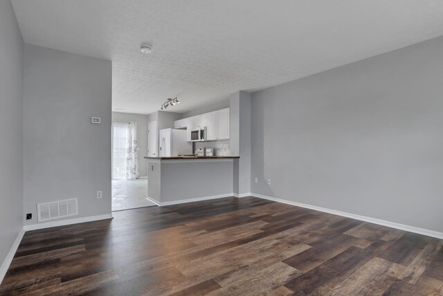 6022 Brice Park Dr Unit 17D, Canal Winchester, OH 43110 - unfurnished living room featuring dark wood-style flooring, baseboards, and a textured ceiling