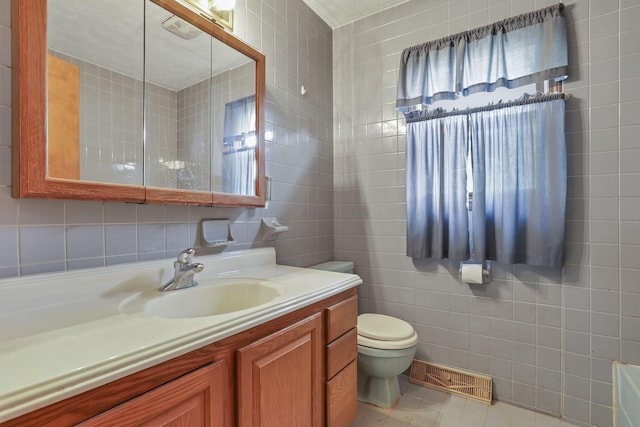 907 Fairfield Ave, Lancaster, OH 43130 - bathroom featuring tile walls, toilet, vanity, tile patterned flooring, and tasteful backsplash