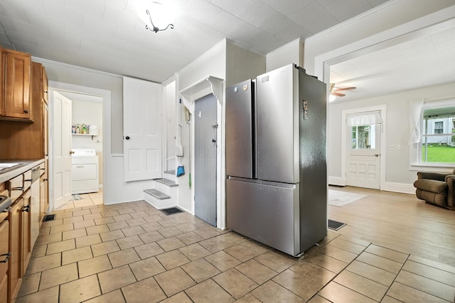 101 Meadow Ln, Gambier, OH 43022 - kitchen with freestanding refrigerator, washer / dryer, a ceiling fan, brown cabinetry, and light tile patterned flooring