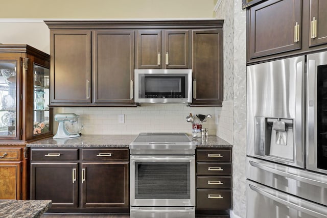 217 Warbler Ct, Pickerington, OH 43147 - kitchen featuring appliances with stainless steel finishes, dark brown cabinetry, dark stone countertops, and tasteful backsplash