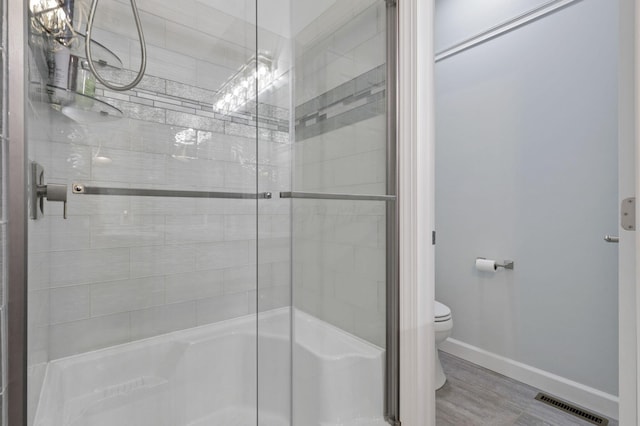 217 Warbler Ct, Pickerington, OH 43147 - full bath with a tile shower, toilet, wood finished floors, and baseboards