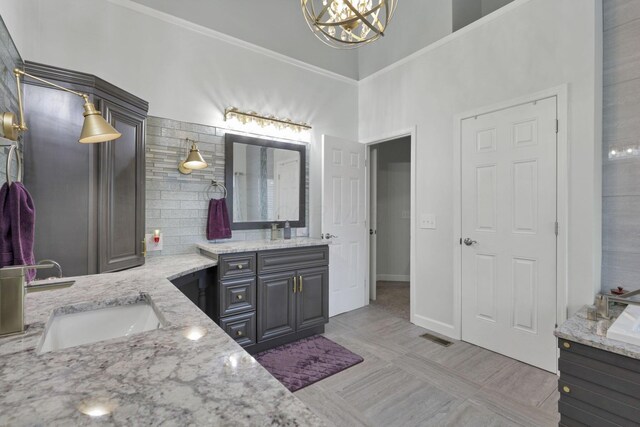 217 Warbler Ct, Pickerington, OH 43147 - full bathroom with two vanities, a chandelier, baseboards, a towering ceiling, and crown molding