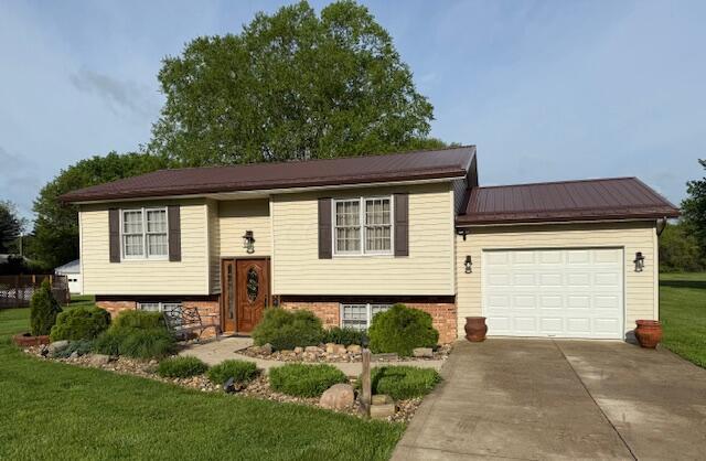 14629 Hock Hocking Rd, Logan, OH 43138 - raised ranch featuring driveway, a garage, a front yard, and metal roof