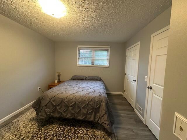 14629 Hock Hocking Rd, Logan, OH 43138 - bedroom featuring a textured ceiling, wood finished floors, and baseboards