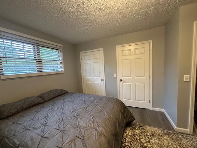 14629 Hock Hocking Rd, Logan, OH 43138 - bedroom featuring wood finished floors, a textured ceiling, and baseboards
