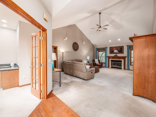 1397 Horseshoe Rd, Delaware, OH 43015 - carpeted living area featuring ceiling fan, high vaulted ceiling, a glass covered fireplace, wood finished floors, and baseboards