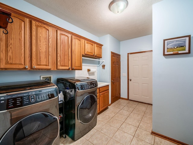 1397 Horseshoe Rd, Delaware, OH 43015 - laundry room featuring washing machine and clothes dryer, cabinet space, baseboards, a textured ceiling, and light tile patterned floors