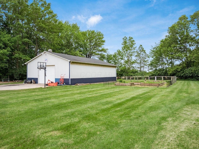 1397 Horseshoe Rd, Delaware, OH 43015 - view of grassy yard with a detached garage, an outbuilding, a vegetable garden, and view of wooded area