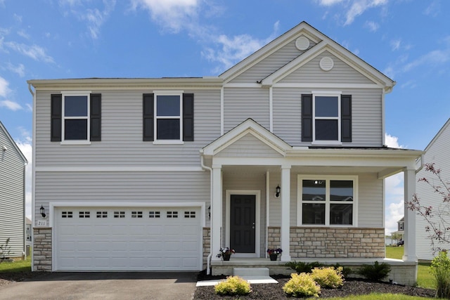 211 Whitetail Trl, Johnstown, OH 43031 - view of front facade featuring stone siding, a garage, asphalt driveway, and covered porch