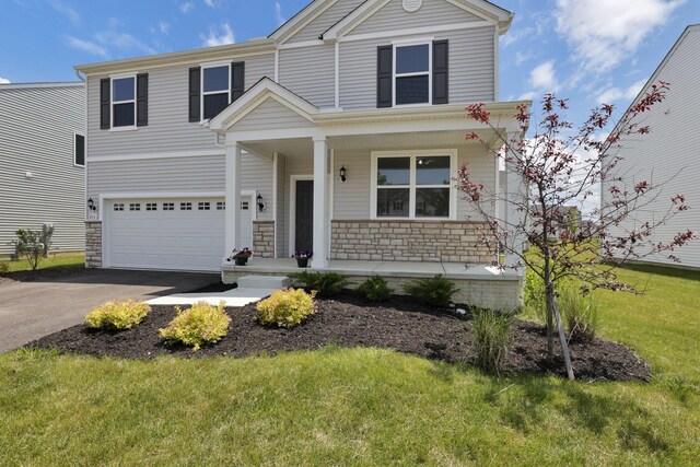 211 Whitetail Trl, Johnstown, OH 43031 - view of front of property featuring covered porch, driveway, stone siding, an attached garage, and a front yard