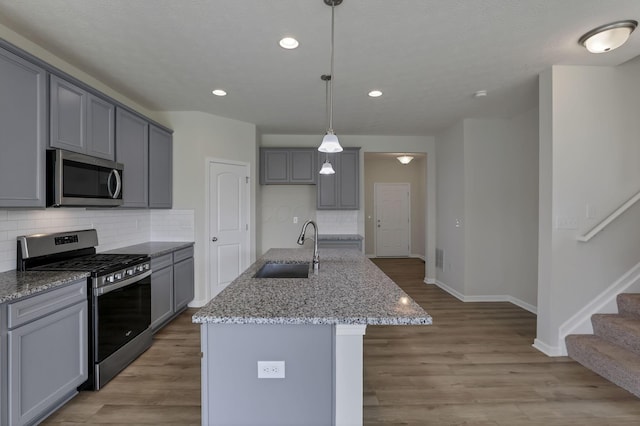 211 Whitetail Trl, Johnstown, OH 43031 - kitchen featuring stainless steel appliances, a sink, gray cabinetry, light stone counters, and decorative backsplash