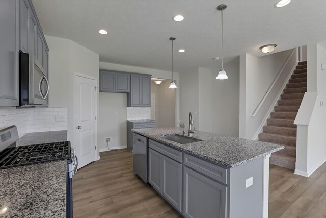 211 Whitetail Trl, Johnstown, OH 43031 - kitchen with appliances with stainless steel finishes, a sink, light wood finished floors, light stone countertops, and tasteful backsplash