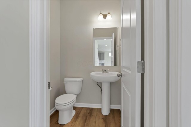211 Whitetail Trl, Johnstown, OH 43031 - half bathroom featuring toilet, wood finished floors, a sink, and baseboards