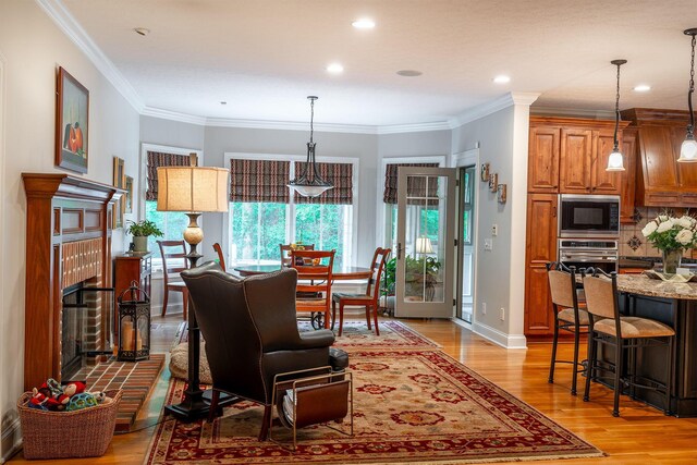 7699 Clear Creek Ct, Blacklick, OH 43004 - living room with light wood finished floors, a brick fireplace, ornamental molding, recessed lighting, and baseboards