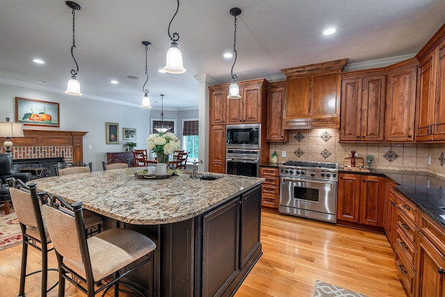 7699 Clear Creek Ct, Blacklick, OH 43004 - kitchen featuring appliances with stainless steel finishes, a sink, ornamental molding, a breakfast bar, and brown cabinetry