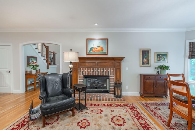 7699 Clear Creek Ct, Blacklick, OH 43004 - living room featuring light wood-style floors, ornamental molding, a fireplace, baseboards, and arched walkways