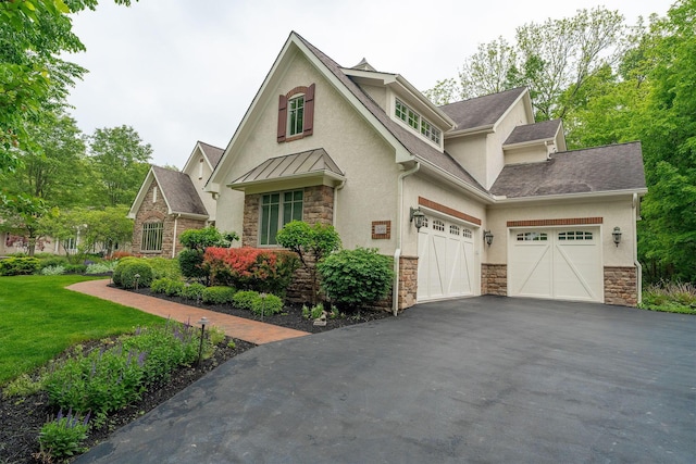 7699 Clear Creek Ct, Blacklick, OH 43004 - view of front facade featuring stucco siding, stone siding, driveway, roof with shingles, and a standing seam roof