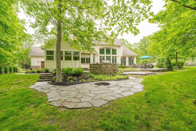 7699 Clear Creek Ct, Blacklick, OH 43004 - rear view of property with stucco siding, a lawn, a patio area, and stone siding