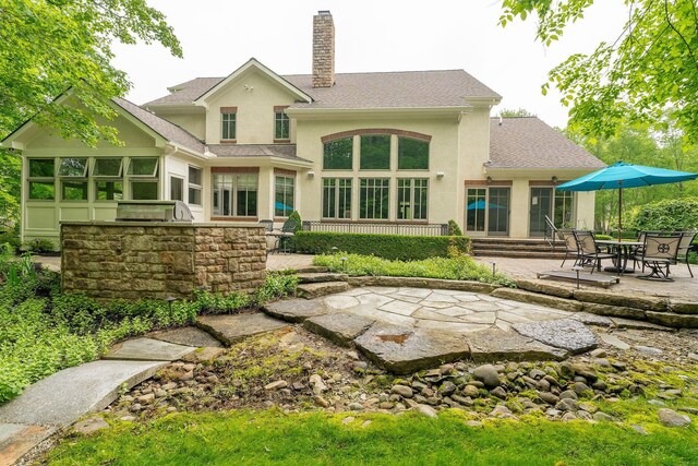 7699 Clear Creek Ct, Blacklick, OH 43004 - back of house featuring stucco siding, a chimney, a patio, and roof with shingles