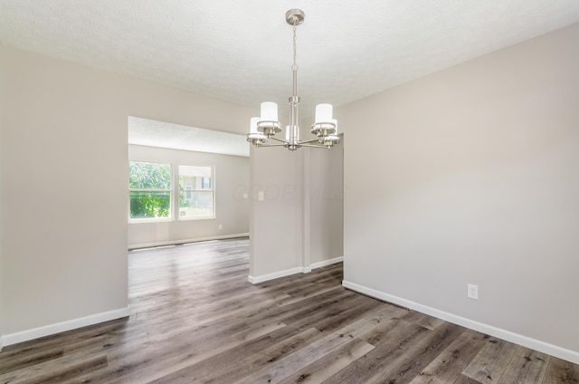 3248 Medoma Dr, Columbus, OH 43204 - spare room with a chandelier, wood finished floors, and a textured ceiling