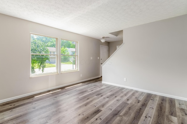 3248 Medoma Dr, Columbus, OH 43204 - spare room with wood finished floors, a textured ceiling, and stairs