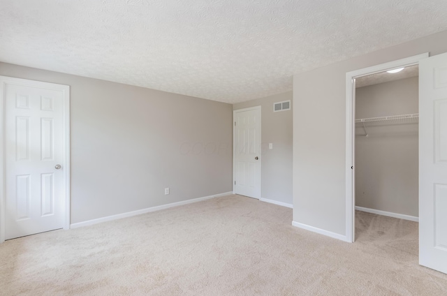 3248 Medoma Dr, Columbus, OH 43204 - unfurnished bedroom with carpet flooring, a spacious closet, a textured ceiling, and a closet