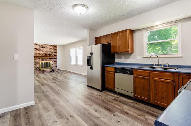 3248 Medoma Dr, Columbus, OH 43204 - kitchen featuring dishwasher, stainless steel fridge, a textured ceiling, brown cabinets, and light wood-type flooring