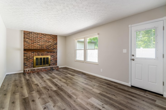 3248 Medoma Dr, Columbus, OH 43204 - unfurnished living room with healthy amount of natural light, wood finished floors, a textured ceiling, and a fireplace