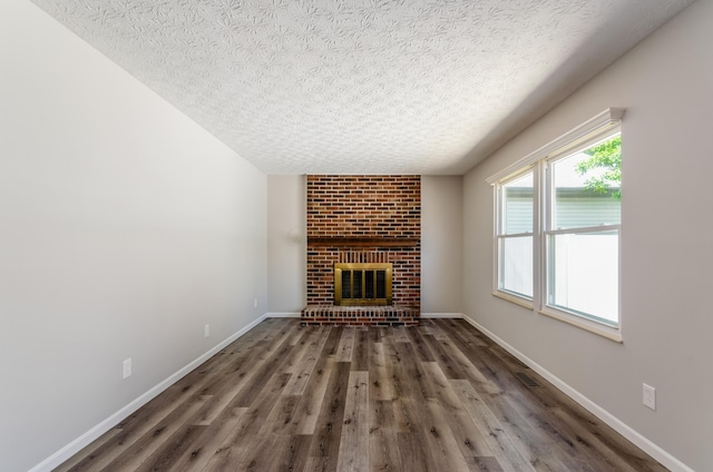 3248 Medoma Dr, Columbus, OH 43204 - unfurnished living room featuring a textured ceiling, wood finished floors, and a brick fireplace