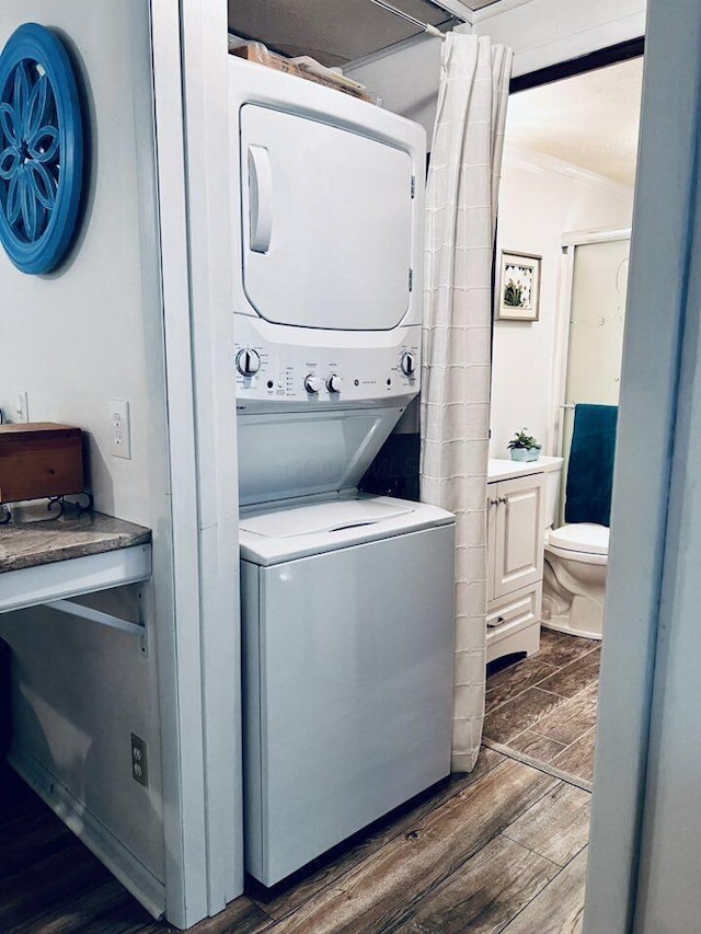 3037 La Vista Dr Unit 39, Columbus, OH 43204 - laundry area with stacked washer / drying machine, wood finished floors, and crown molding