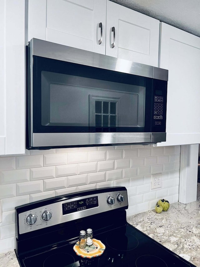 3037 La Vista Dr Unit 39, Columbus, OH 43204 - kitchen view of stainless steel appliances, decorative backsplash, and white cabinetry