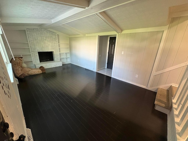 5464 Aspen Rd, Columbus, OH 43229 - unfurnished living room featuring hardwood / wood-style floors, a textured ceiling, a fireplace, baseboards, and built in features